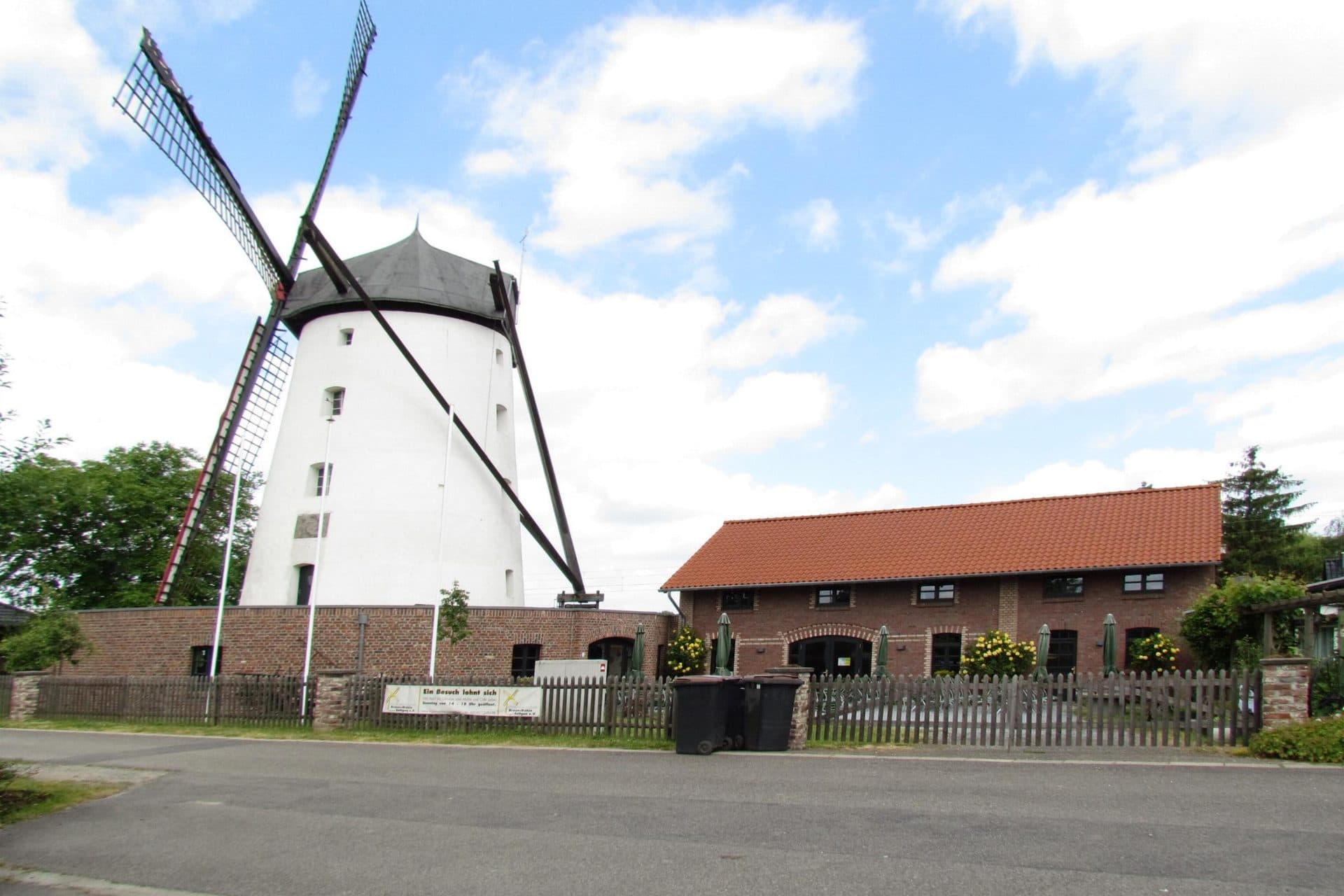 Braunsmühle in Kaarst-Büttgen, historische weiße Turmwindmühle mit Flügeln vor blauem Himmel