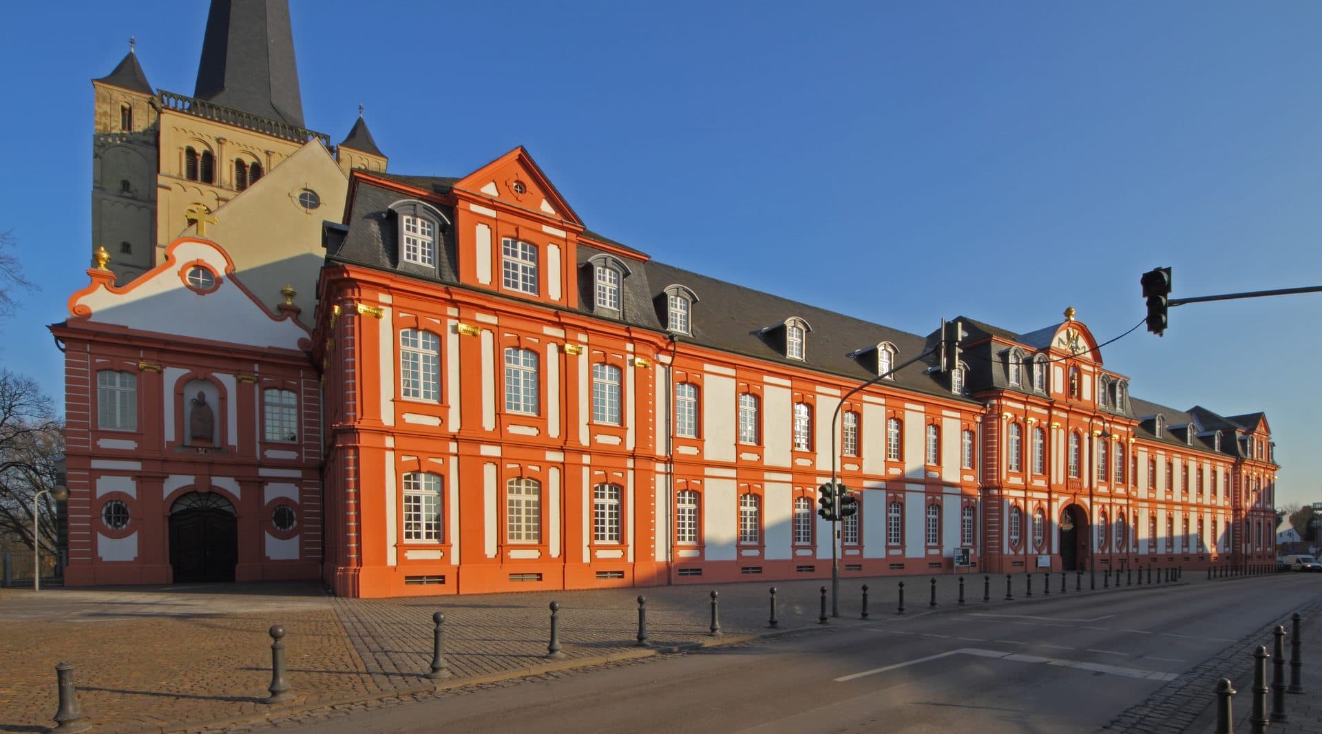 Abtei Brauweiler in Pulheim, barocke Backsteinfassade mit den romanischen Türmen der Abteikirche im Abendlicht
