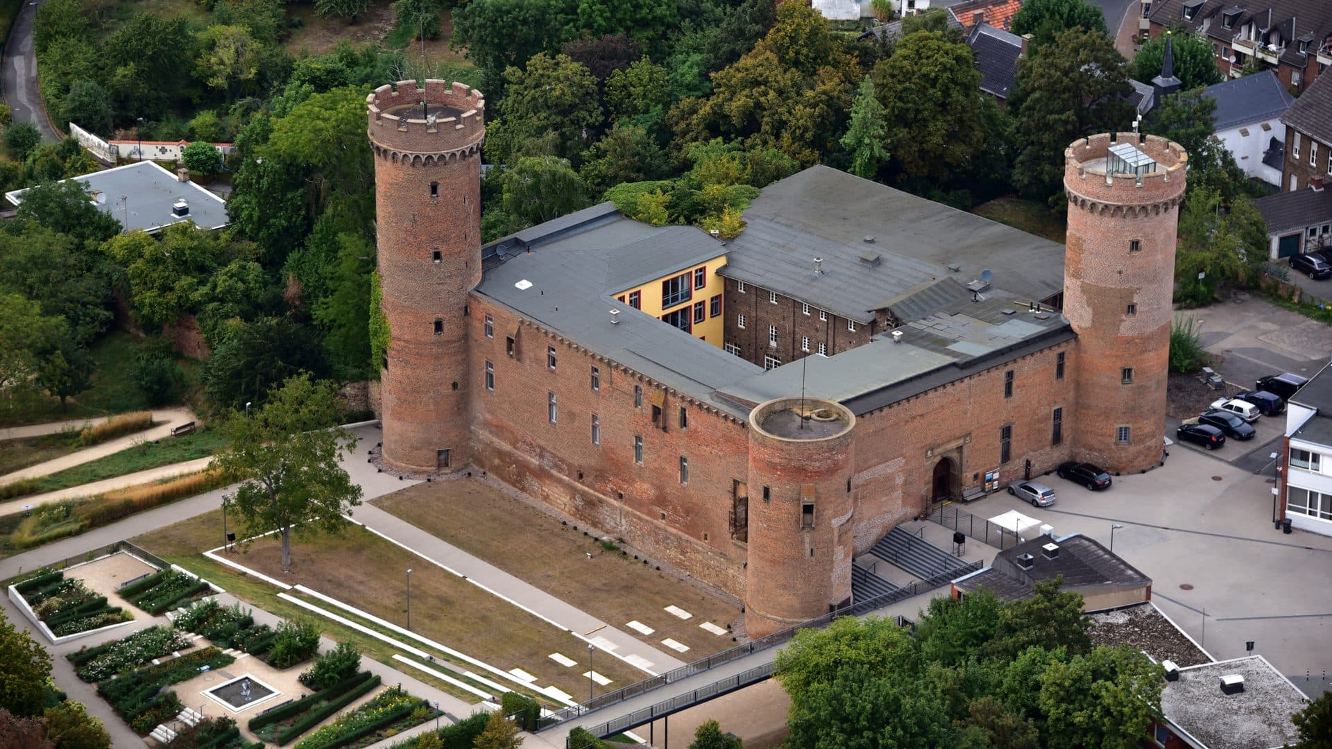 Kurkölnische Landesburg Zülpich mit ihren zwei Rundtürmen und dem Rosengarten aus der Luft